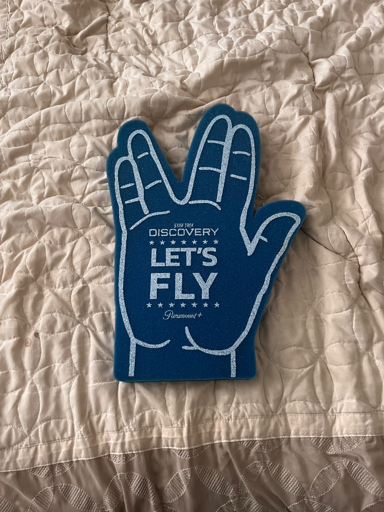 A foam finger/hand in the style of a Vulcan salute. On it, it says “Star Trek: Discovery | Let’s Fly”.